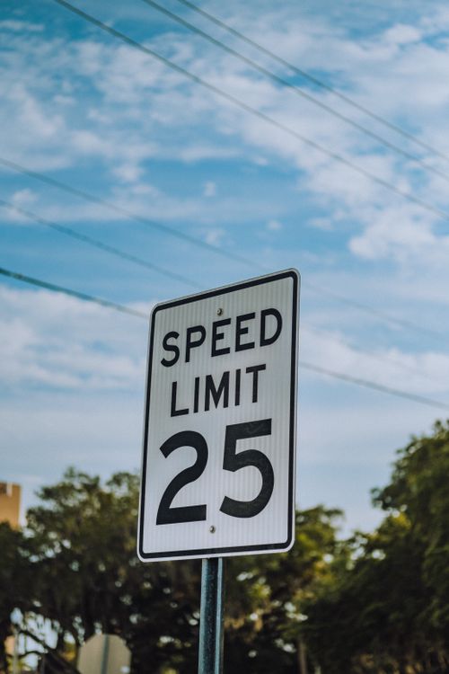 Free A speed limit 25 sign photographed against a clear blue sky in a city environment. Stock Photo