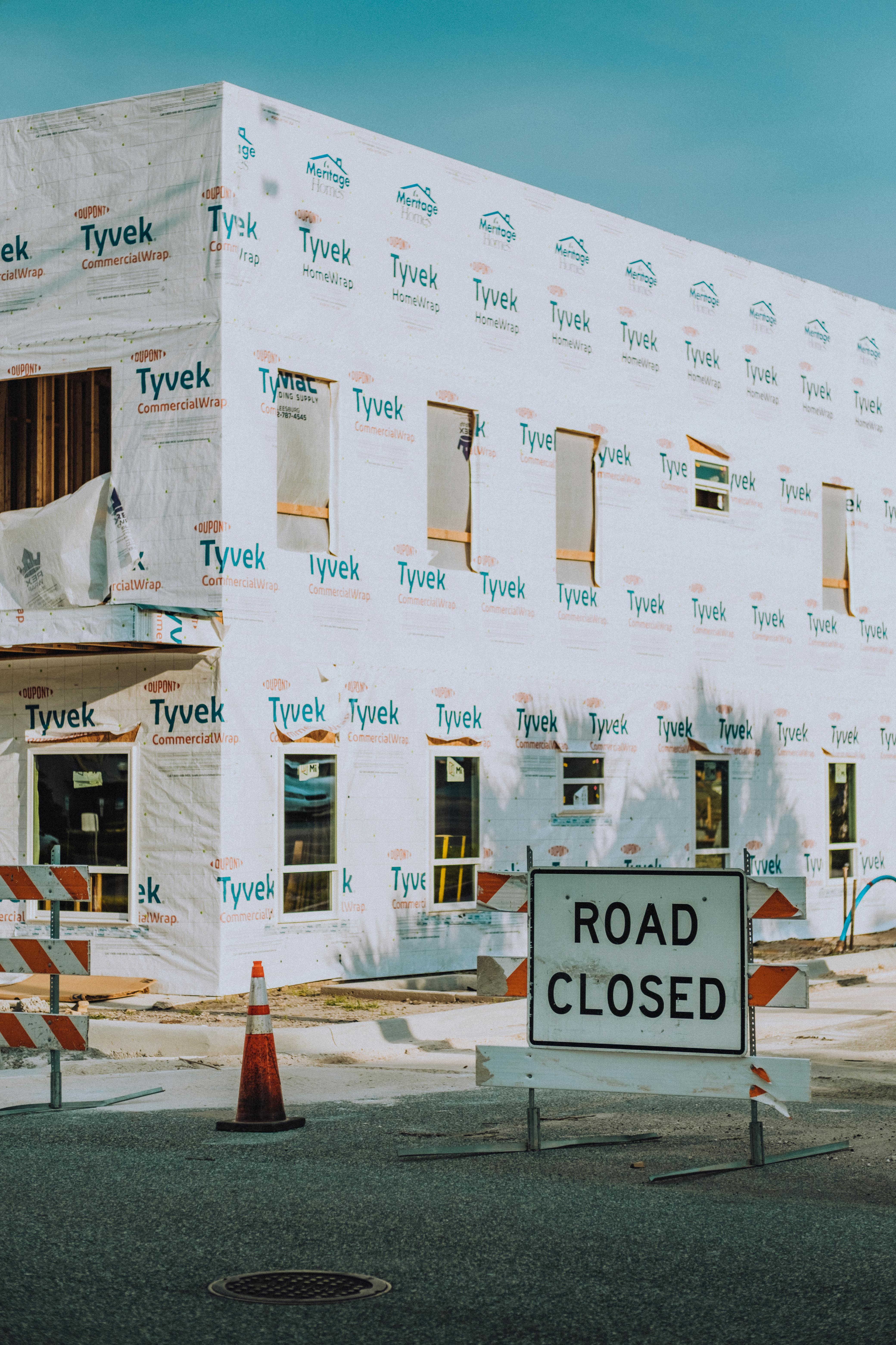 New building under construction with a road closed sign in the foreground.