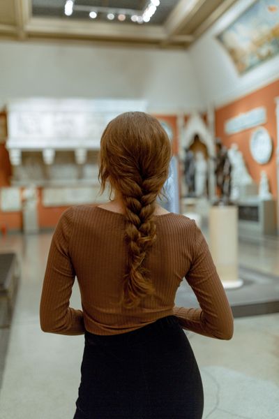 A visitor standing among paintings in a gallery