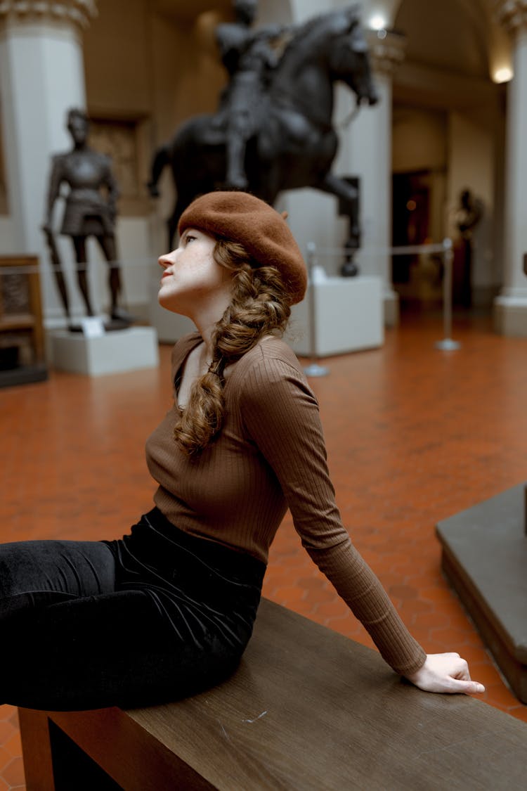 A Woman Sitting In A Museum