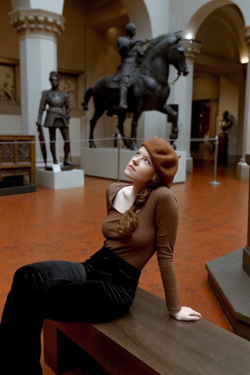 Woman in Black Dress Sitting on Brown Wooden Floor