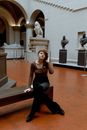 Woman in Black Tank Top and Black Pants Sitting on Brown Wooden Bench
