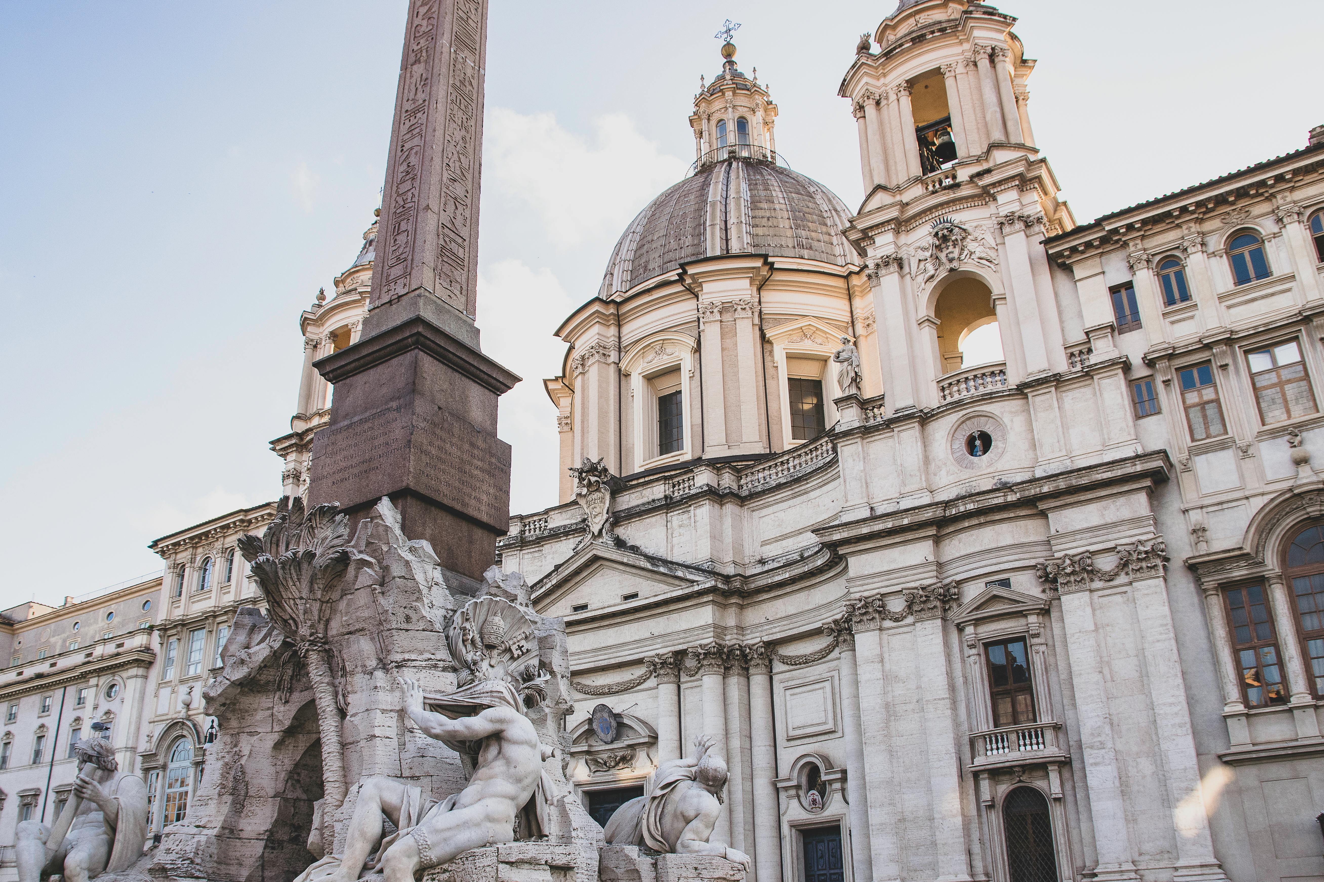 Piazza Navona in Rome with Bernini's Fountain of the Four Rivers, Baroque churches, and an obelisk surrounded by outdoor cafés and visitors enjoying the lively atmosphere of one of Rome's most beautiful squares