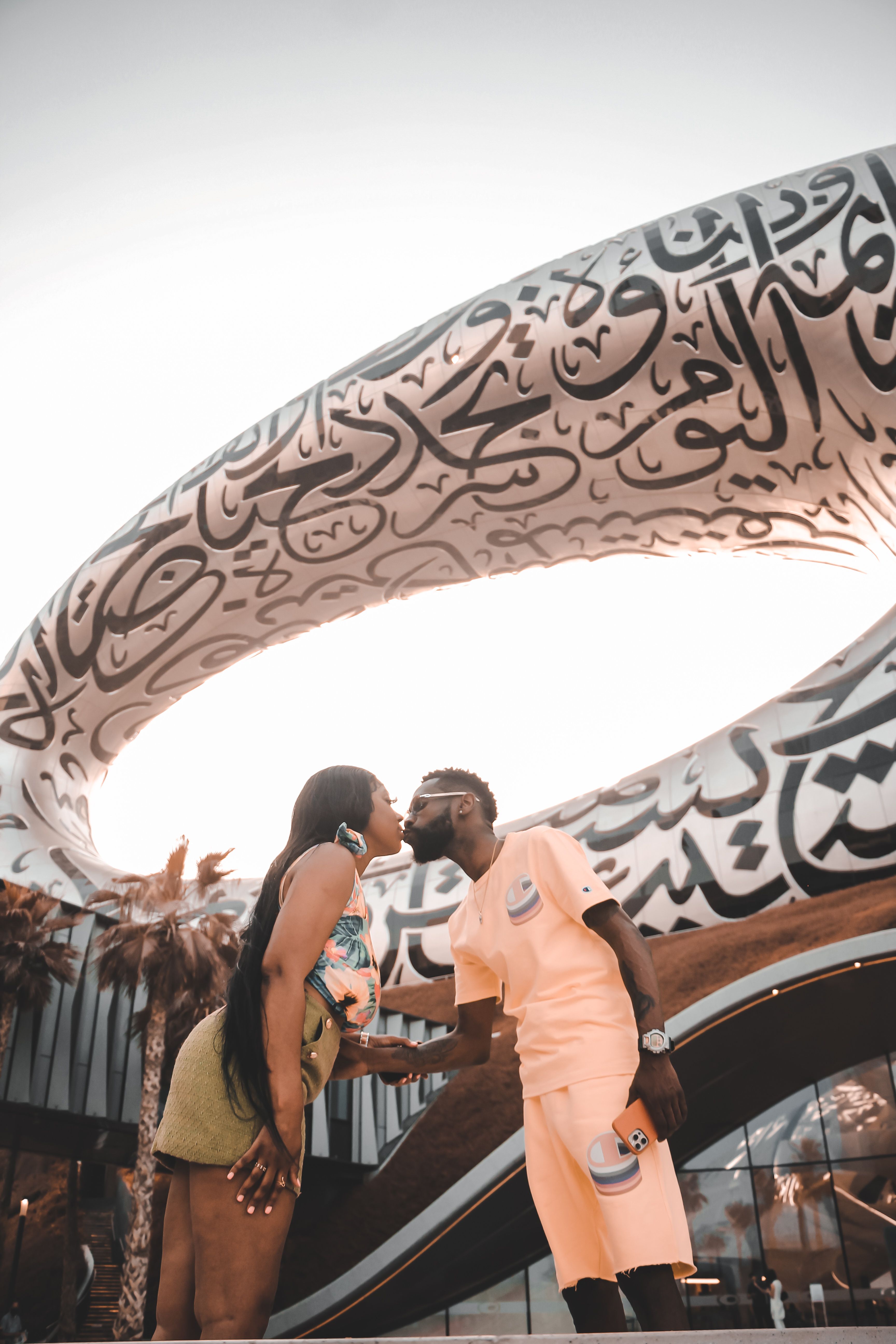 A couple shares a romantic kiss in front of Dubai's iconic Museum of the Future.