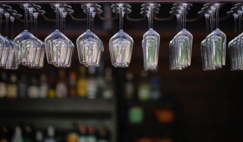 Free Close-up of cocktail glasses hanging upside down with blurred bar background. Stock Photo