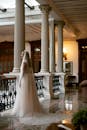 Woman in White Wedding Dress Standing on White Concrete Staircase