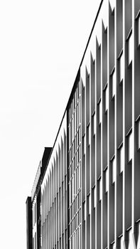 A striking black and white photo showcasing a modern facade in Nitra, Slovakia, highlighting geometric patterns and shadows.