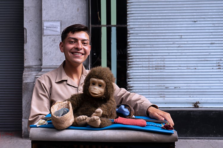 Man In Brown Long Sleeves With Monkey Stuff Toy 