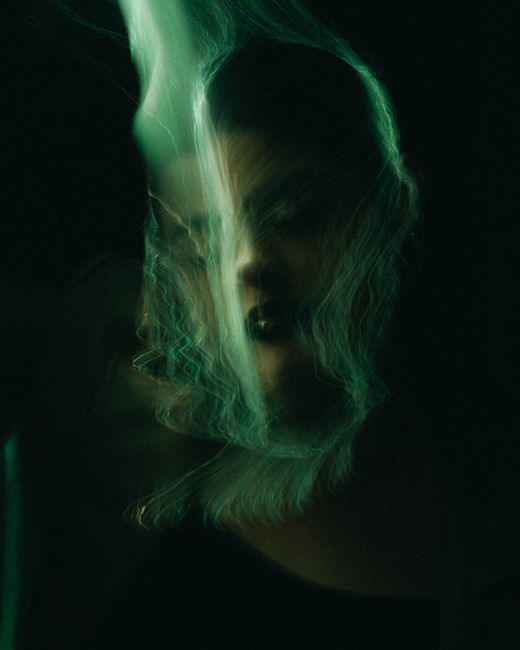 Mysterious portrait with abstract light effects blending color and form.