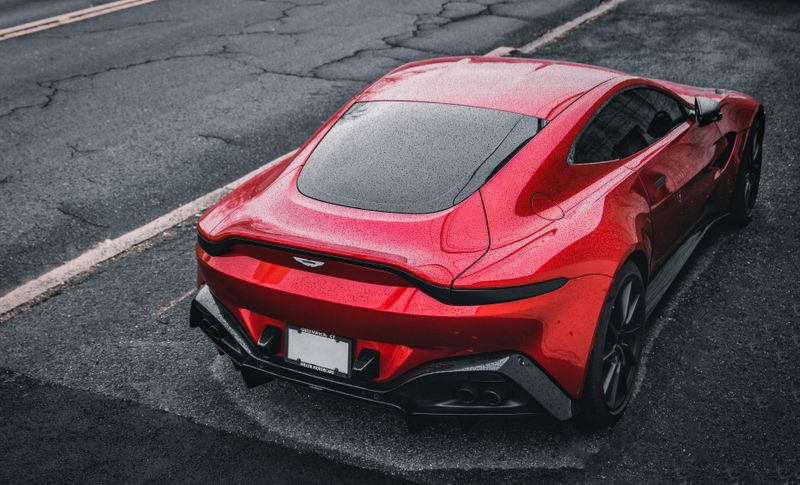 Red Aston Martin on wet urban street