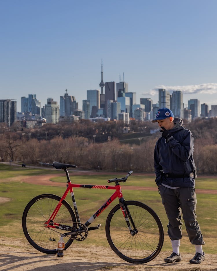 Man Smoking Beside A Parked Bicycle