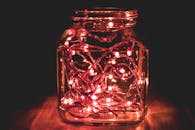 粉红色的仙女灯在玻璃罐内闪烁，营造出温暖舒适的氛围