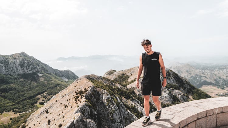 Man In Black Tank Top And Shorts Walking On The Edge