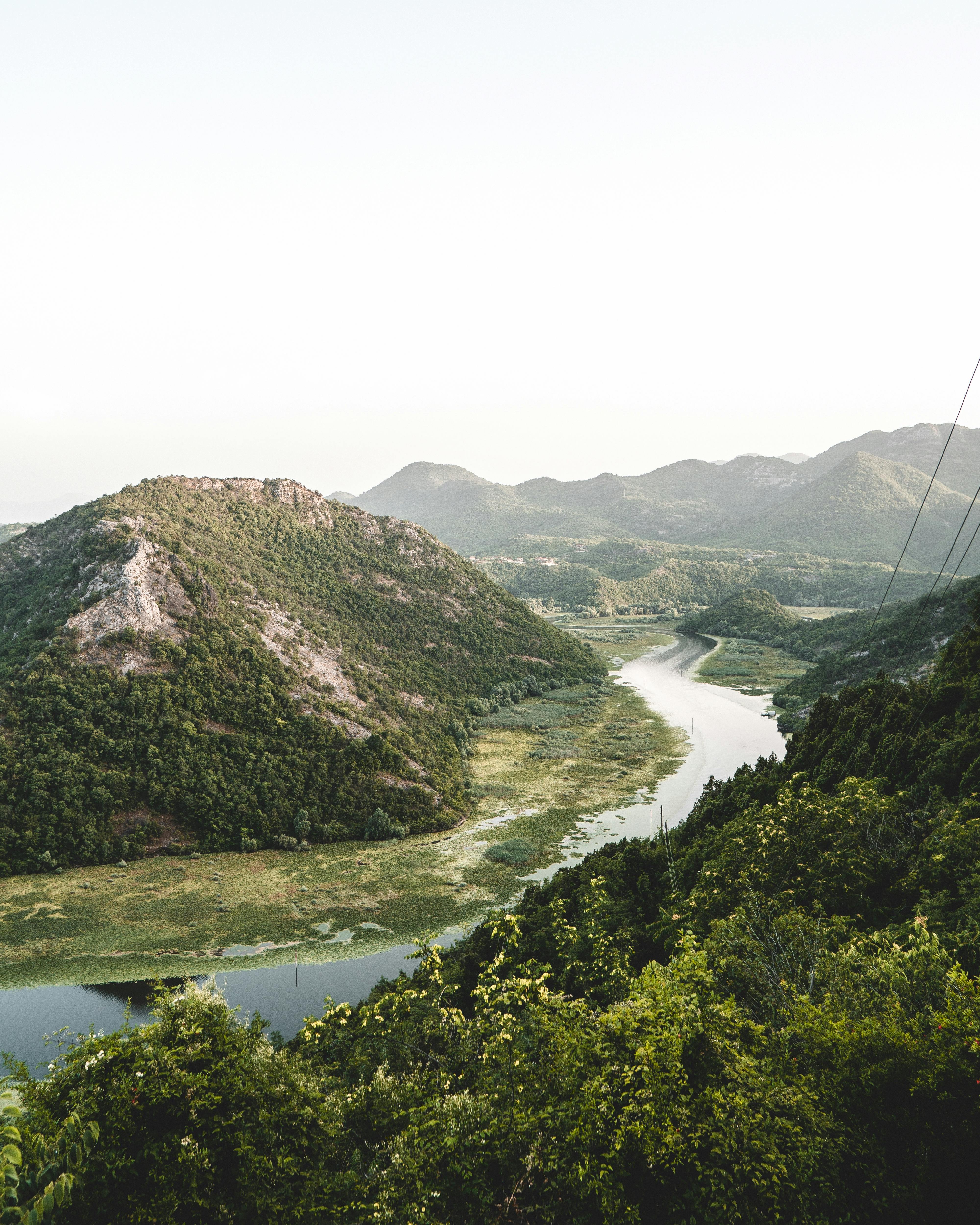 Beautiful scenic landscape of Shkodra Lake bend surrounded by lush greenery and mountains in Montenegro.