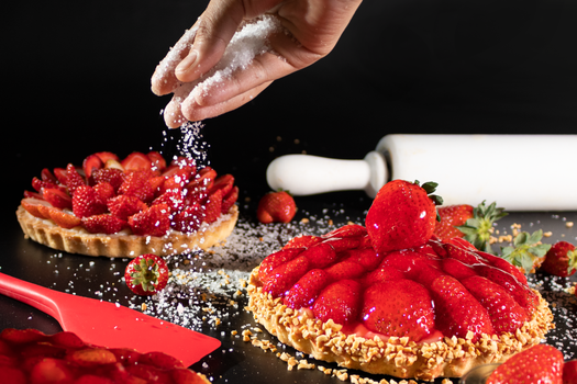 A close-up of a delicious strawberry tart being sprinkled with sugar. Captured indoors, São Paulo, Brazil.