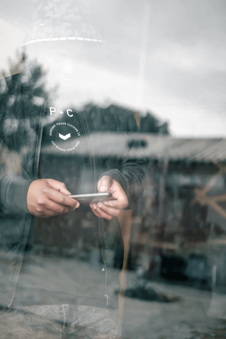 Person With Smartphone Behind Window