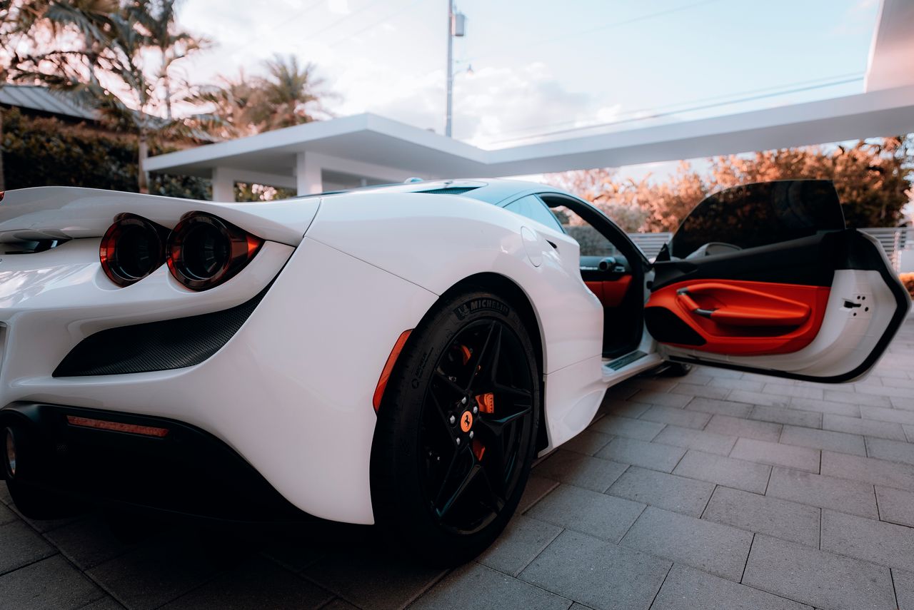 luxurious white sports car with open door in an outdoor setting showca