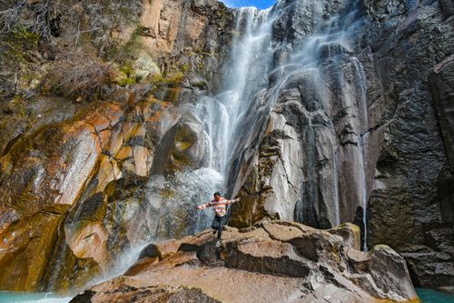 Free Person joyfully experiencing the majesty of Cusárare Waterfall, Guachochi, Mexico. Stock Photo