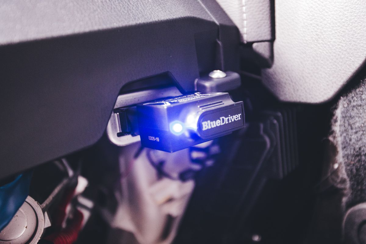 Close-up of an electronic diagnostic scan tool plugged into a vehicle