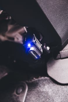 A detailed close-up of a BlueDriver Bluetooth code reader plugged into a vehicle.