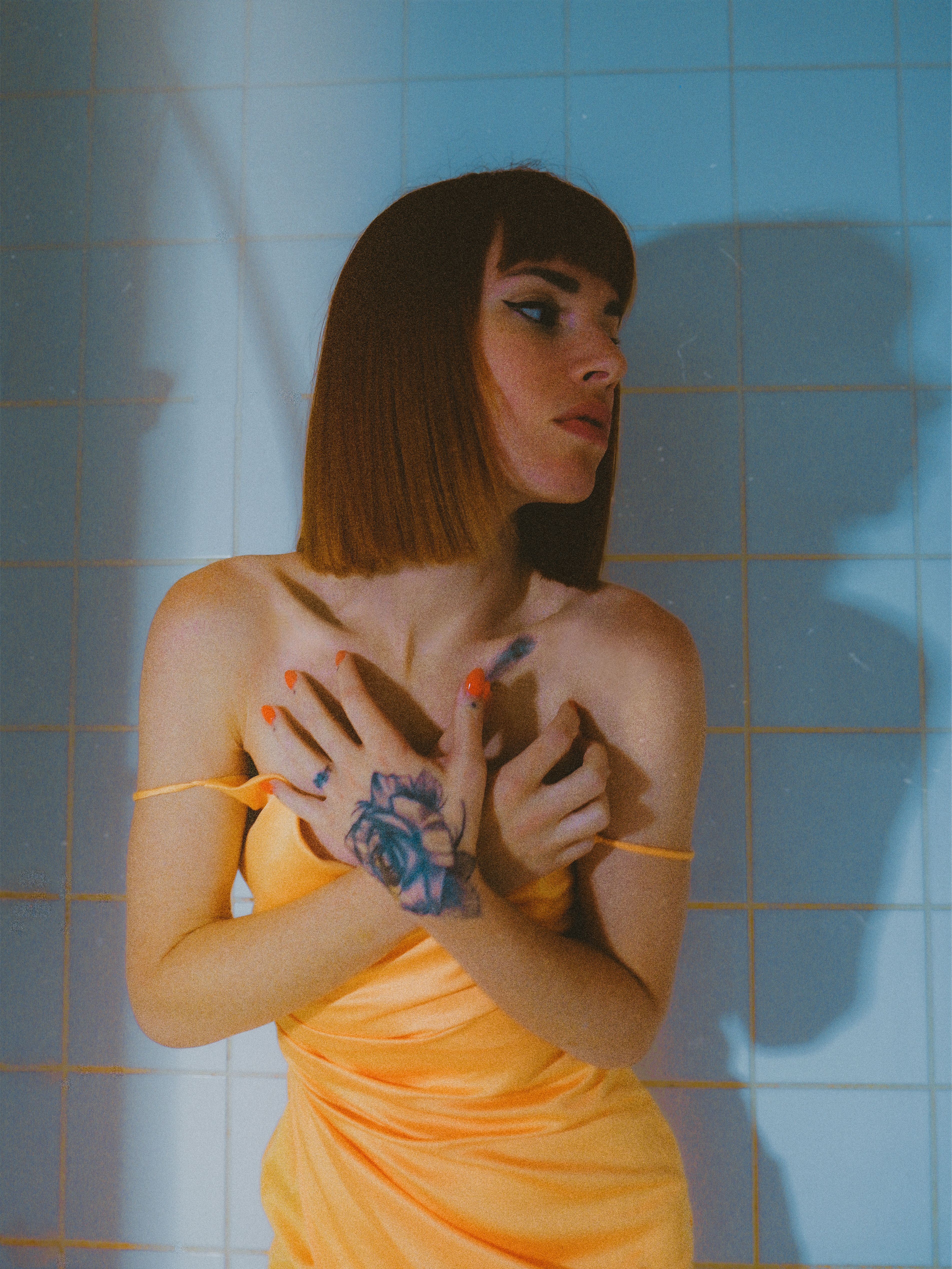 Unique artistic portrait of a woman casting shadows with distinct tattooed hands.