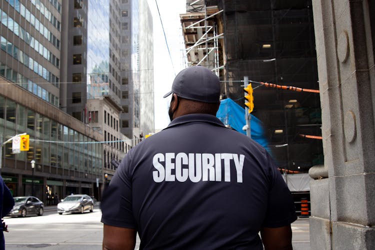 Security Guard In Uniform Patrolling In A Commercial Area