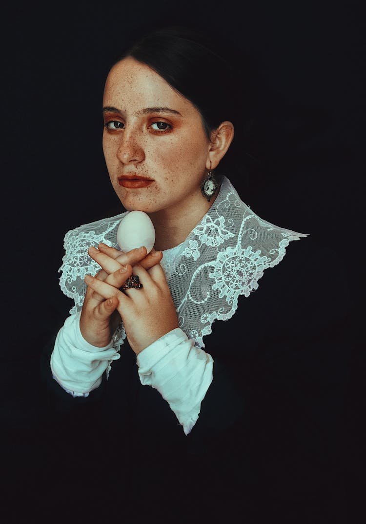 Portrait Of A Woman In Lace Collar Holding A White Egg