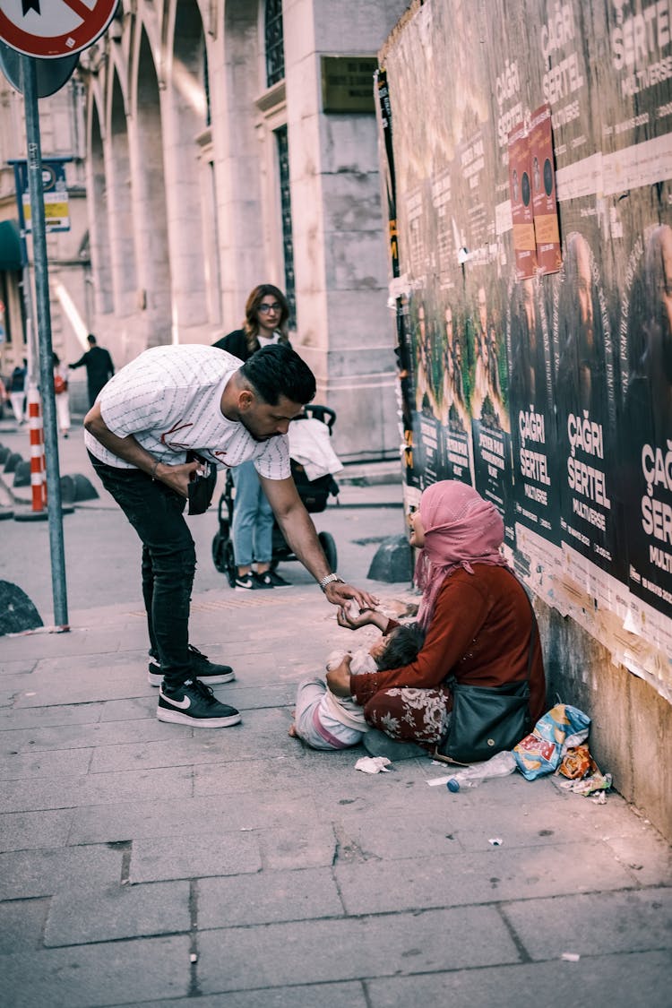 A Man Giving To A Beggar On The Street