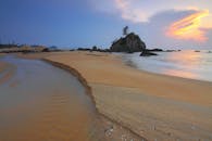 沙滩上，宁静的日出伴随着柔和的波浪和充满活力的天空