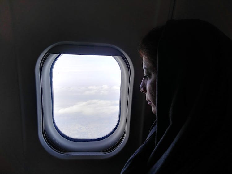 Woman Looking Through Airplane Window