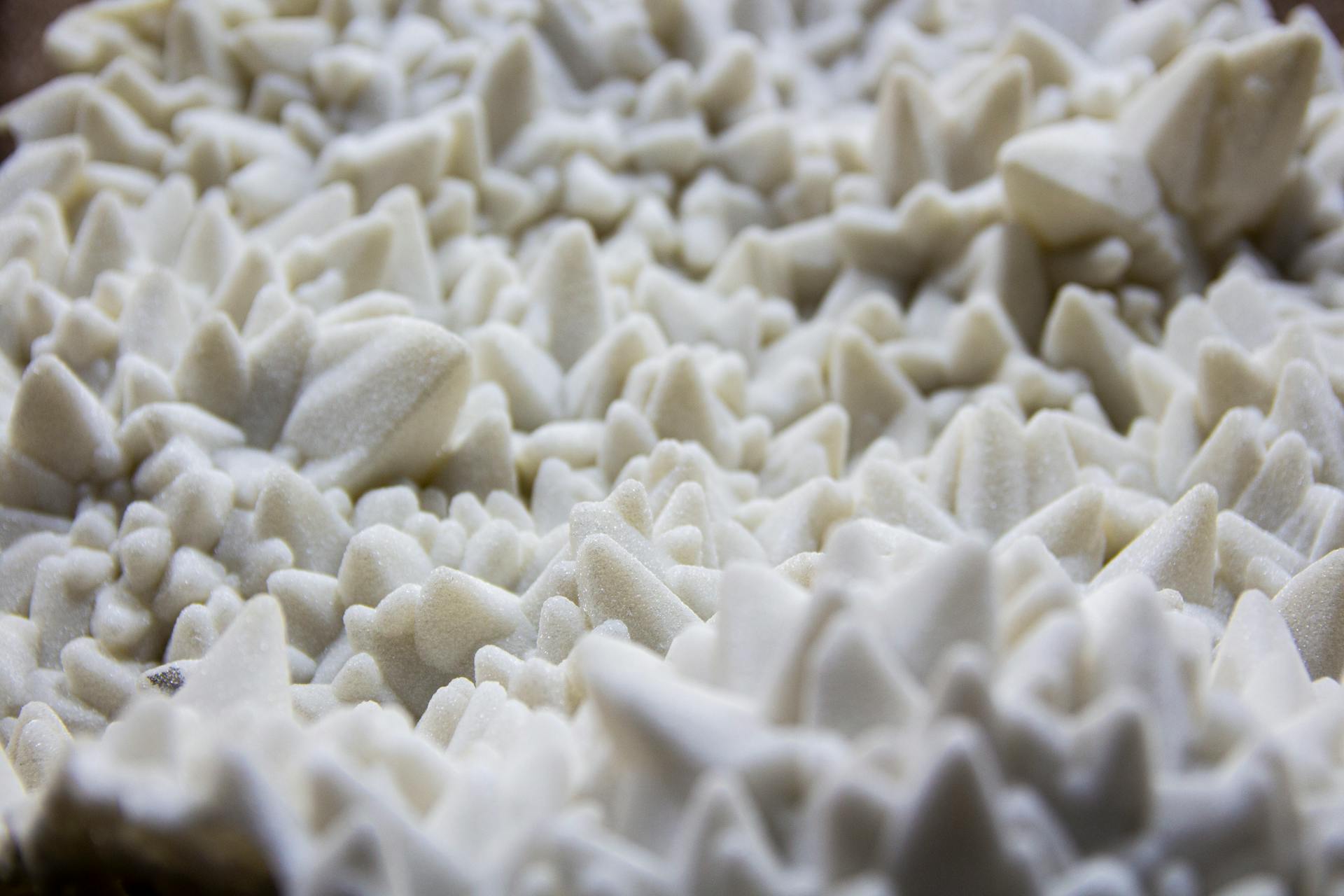 Close-up of a textured white mineral crystal surface showing intricate formations.