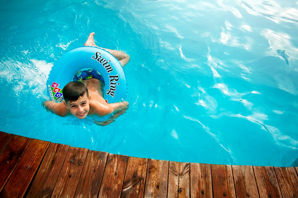 Boy Floating in Pool With Water Ring
