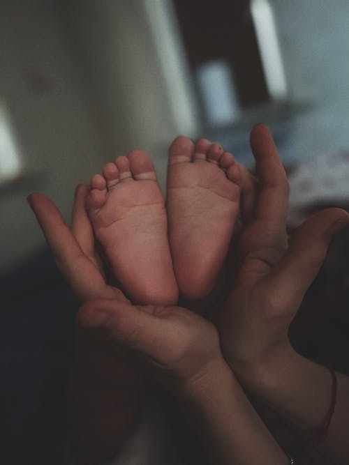 Person Holding a Baby's Feet 