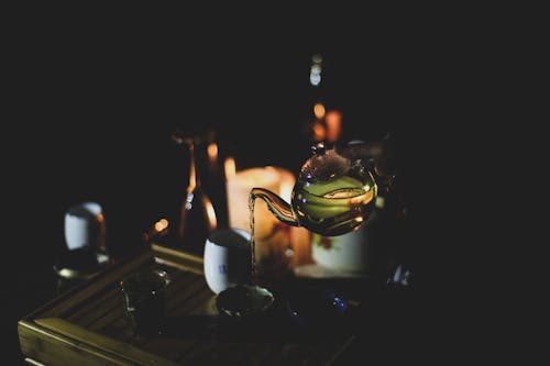 Person Pouring a Hot Tea on a Small Cup