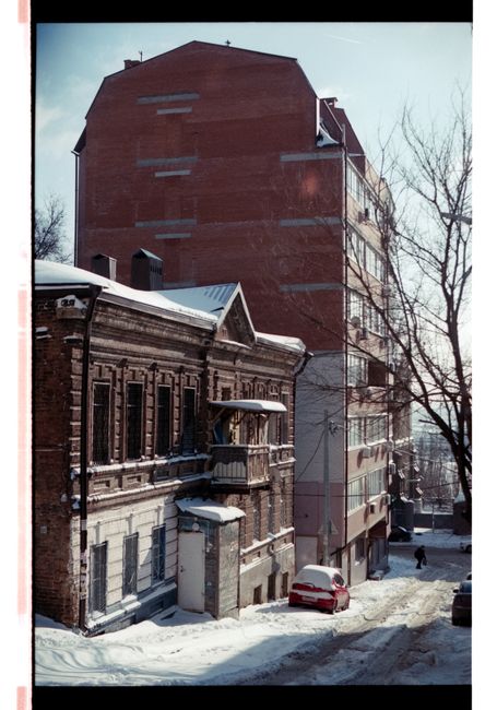A street scene capturing snow-covered historic and modern buildings under a clear winter sky.