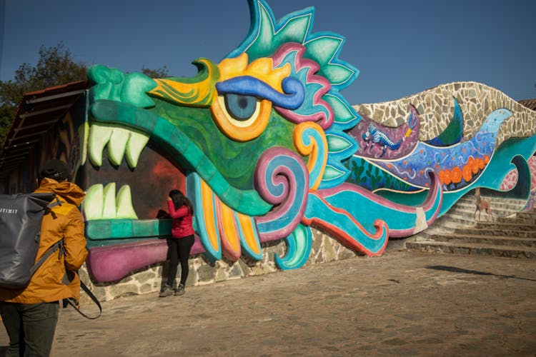 People Standing Beside Multicolored Wall Painting