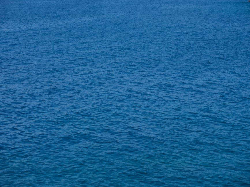 Fotomural Una vista vasta y tranquila del océano azul capturada desde arriba, mostrando texturas serenas en el agua.
