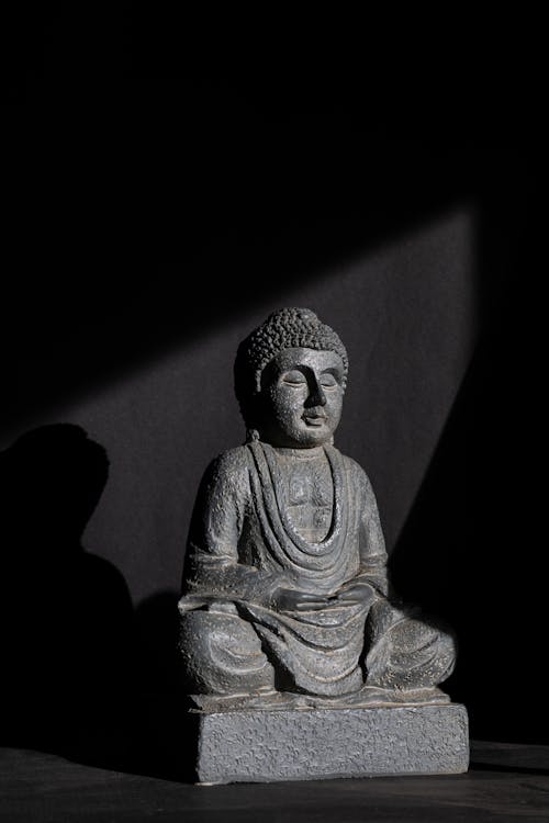 A Gray Buddha Statue on Black Background 