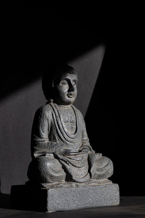 A Gray Buddha Statue on Black Background
