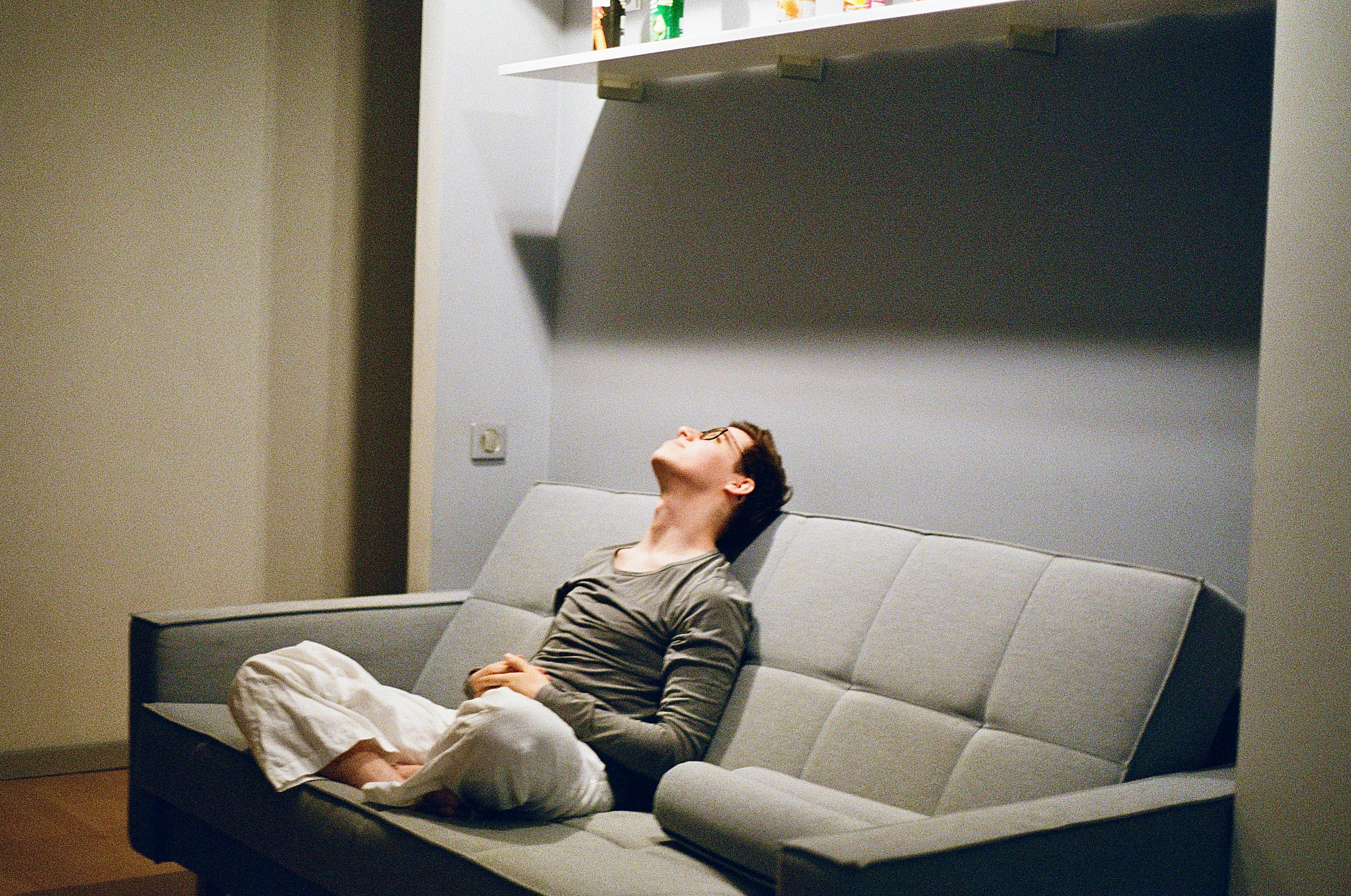 This photo shows a person sitting on a sofa.