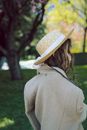 Woman in Beige Sun Hat and Gray Coat Standing on Green Grass Field