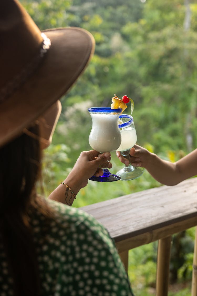 A Woman Holding A Glass With Pina Colada Cocktail