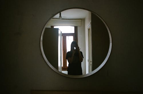 Person Standing in Front of a Mirror Holding a Camera