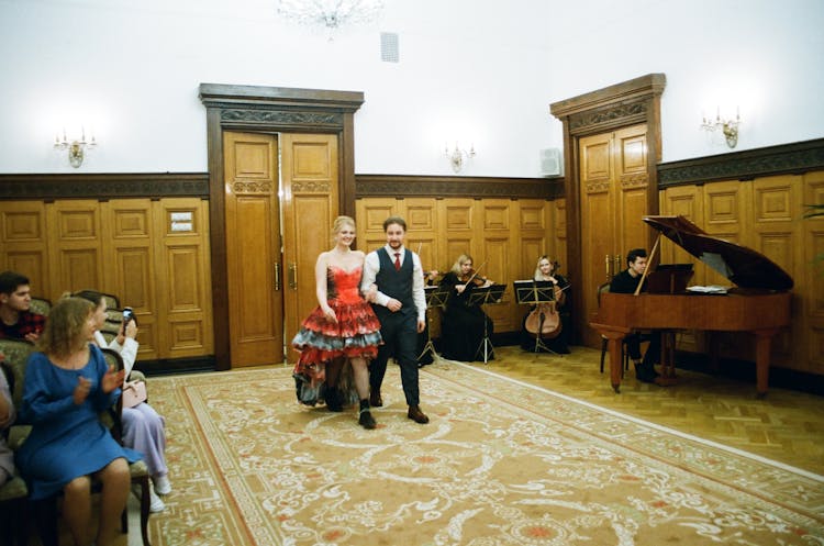 Young Couple Smiling In Formal Clothes Walking On Aisle In Reception Area