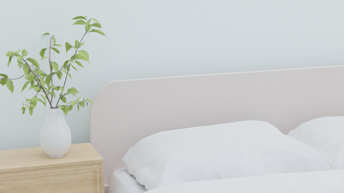 A clean, made bed in a bright bedroom, the setting bed bug treatment aims to restore
