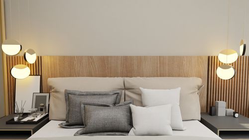 Free A stylish minimalist bedroom design with elegant lighting and cozy pillows. Stock Photo