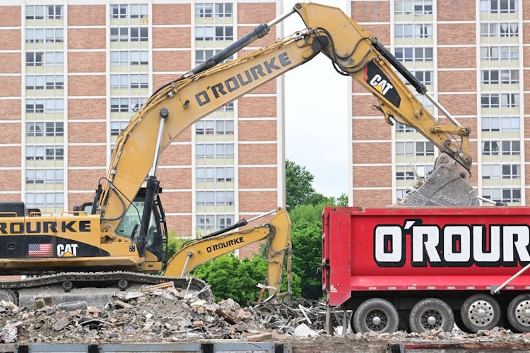 Backhoe Dumping Debris On A Dump Truck