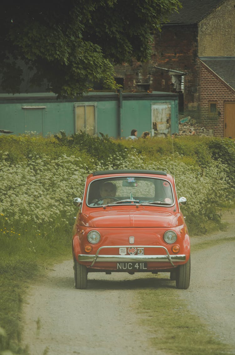 Elderly Man Driving Red Car