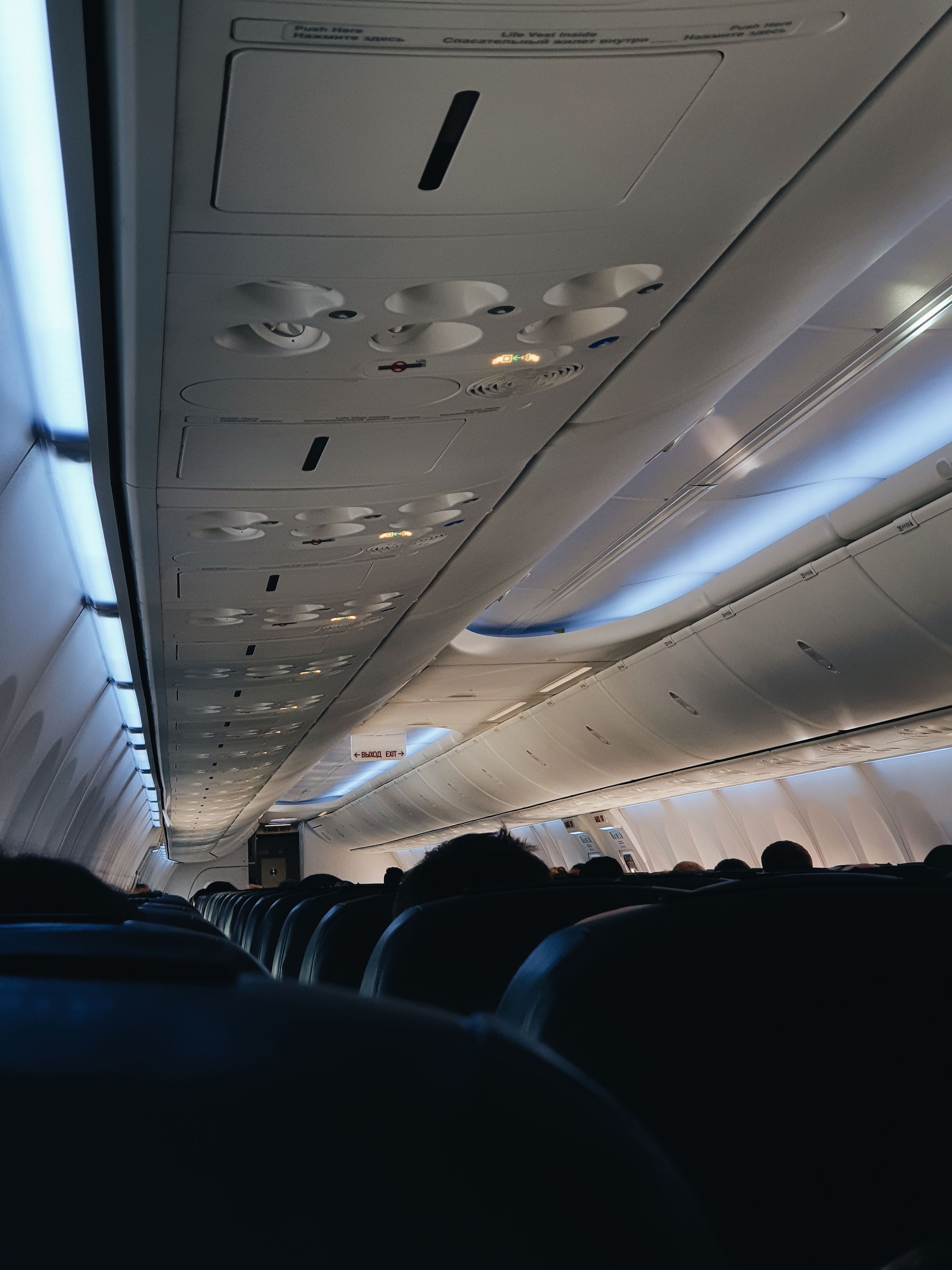 Commercial airplane cabin, overhead compartments and blue seats