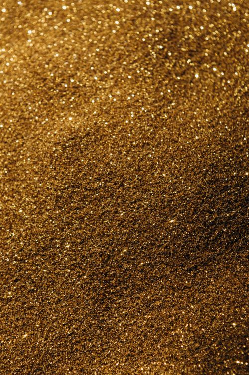 Free Close-up of sparkling golden sand, perfect for backgrounds and textures. Stock Photo